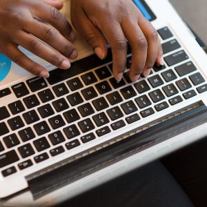 Hands typing on a laptop keyboard